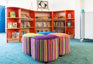 Kincaidston primary chill out area with bookcases and soft colourful stools